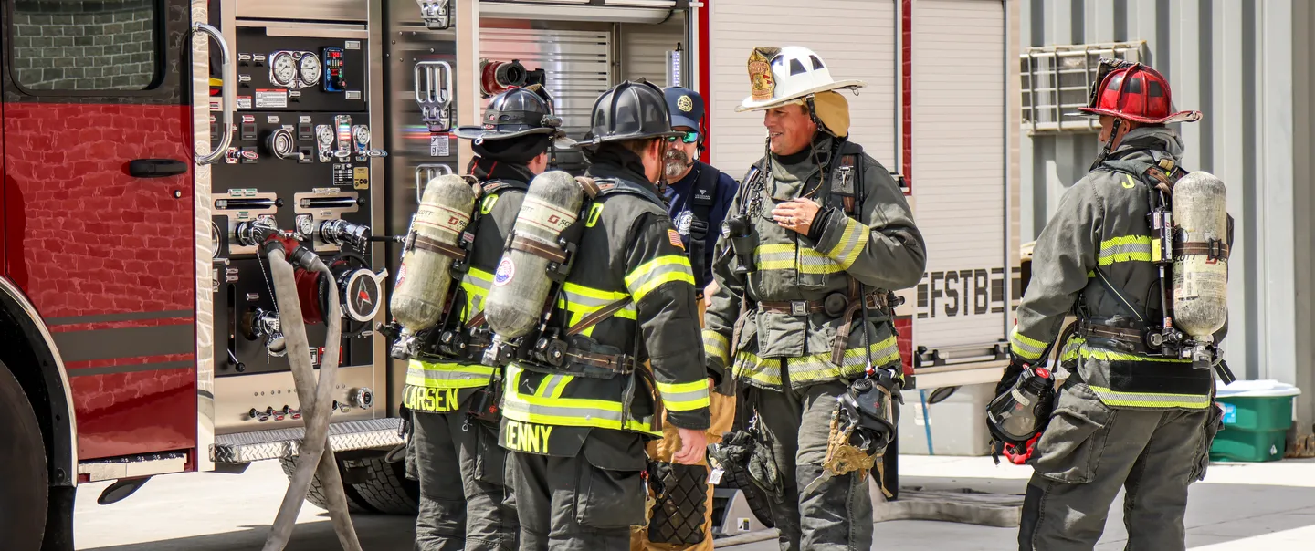 Firemen standing next to fire truck